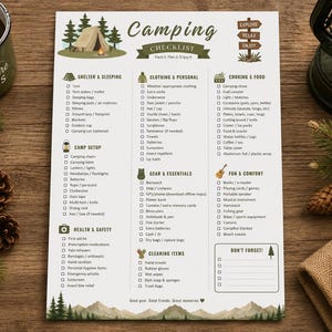 May include: A white paper camping checklist with green and brown text and illustrations of a tent, trees, and mountains. The list includes categories for shelter, clothing, cooking, gear, health, and cleaning, with checkboxes for each item.