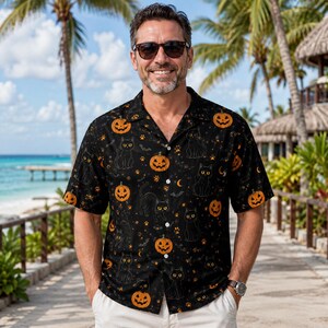 Puede incluir: Una camisa negra de manga corta con botones y un estampado integral de calabazas de Halloween naranjas, gatos negros, pequeños murciélagos y huellas de patas. La camisa cuenta con un cuello clásico y un corte recto y relajado.
