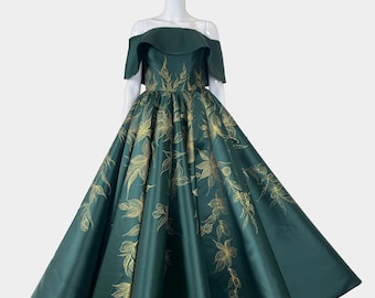 Vestido de gala verde esmeralda a medida con hombros descubiertos y flor dorada pintada a mano, inspirado en "Enredados".
