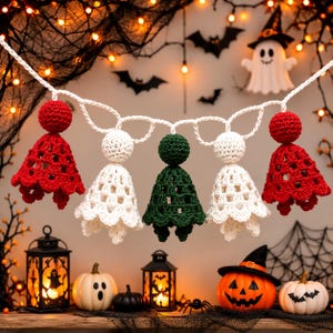 May include: A crochet garland featuring five ghost-shaped figures suspended from a white yarn string. The figures are arranged in a color sequence of red, white, dark green, white, and red, each with a round head and a flared, open-work skirt.