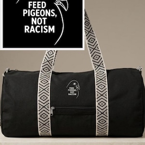 Könnte beinhalten: Eine schwarze Sporttasche mit einer weißen Strichzeichnung eines Taubenkopfes und dem Text FEED PIGEONS, NOT RACISM. Die Tasche hat zwei lange Tragegurte mit einem cremefarbenen und schwarzen geometrischen Muster sowie eine Reißverschlusstasche.