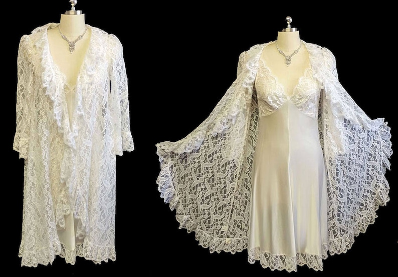 K&ouml;nnte beinhalten: Eine wei&szlig;e Spitzenrobe mit langem, flie&szlig;endem Design. Die Robe hat einen tiefen V-Ausschnitt und lange &Auml;rmel. Die Robe wird mit einem passenden Unterkleid gezeigt.