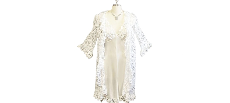 K&ouml;nnte beinhalten: Wei&szlig;es Kleid mit Spitzen&uuml;berwurf und Satinunterkleid. Das Kleid hat einen V-Ausschnitt und lange &Auml;rmel.
