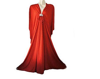 May include: A long, flowing red maxi dress with a V-neckline and a tie detail at the neckline.