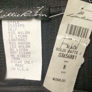 May include: A black dress with a white tag that says "Lillie Rubin" and has the style number 2535595. The tag also lists the fabric composition and care instructions. The dress is priced at $288.00.