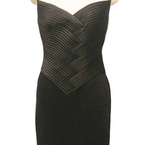 May include: A black sleeveless dress with a pleated bodice and a fitted skirt.