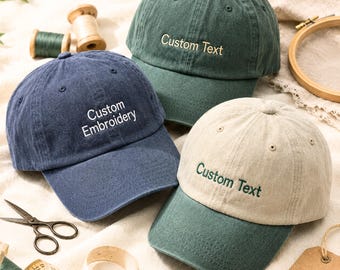 Puede incluir: Tres gorras de béisbol en verde oscuro, azul marino y un diseño bicolor en beige y verde. La gorra azul marino tiene el texto bordado en blanco Custom Embroidery, mientras que las gorras verde y beige tienen el texto bordado Custom Text.