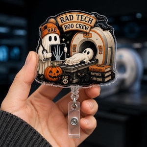 May include: An acrylic badge reel featuring a ghost wearing an orange beanie holding an X-ray, with the text RAD TECH BOO CREW. It depicts a ghost in an MRI machine, a pumpkin, a black cat, and books labeled ANATOMY, PHYSICS, and CAFFEINE.