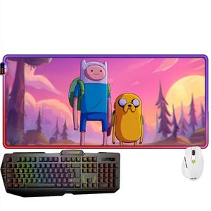 May include: A rectangular desk mat featuring a colorful illustration of Finn and Jake from Adventure Time, a black gaming keyboard with rainbow backlighting, and a white computer mouse with a scroll wheel and side buttons.
