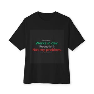May include: A black short-sleeve t-shirt featuring a graphic with the text: ENVIRONMENT: Works in dev. Production? Not my problem. // closes ticket. The text is displayed in white, green, and red against a dark gray square background.