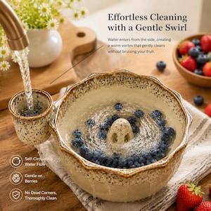 Könnte beinhalten: Eine Keramikschale zum Waschen von Beeren mit beiger Sprenkeloptik und gewelltem Rand. Die Schale verfügt über einen zentralen Abflusskegel und einen seitlichen Einlassbecher für den Wasserfluss. Text auf dem Bild: Effortless Cleaning with a Gentle Swirl.