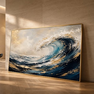 May include: A large rectangular wall art piece featuring an abstract oil painting of a crashing ocean wave. The artwork uses a palette of deep navy blue, white, and metallic gold accents with thick, textured brushstrokes in a thin gold frame.