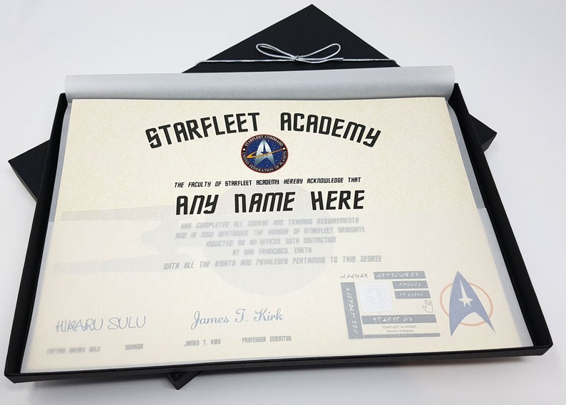 May include: A Starfleet Academy diploma in a black presentation box. The diploma is printed on parchment paper and features the Starfleet Academy logo and the text "STARFLEET ACADEMY". The diploma is signed by "James T. Kirk" and "Hikaru Sulu".