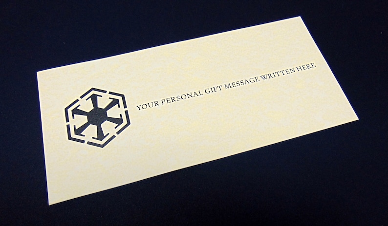 May include: A blank, cream-colored card with a black symbol and the text "YOUR PERSONAL GIFT MESSAGE WRITTEN HERE".