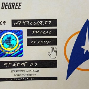 May include: A Starfleet Academy security hologram with a blue and orange Starfleet insignia, a holographic globe, and a hand symbol. The text "TO THIS DEGREE" is at the top of the hologram. The text "STARFLEET ACADEMY" and "Security Hologram" are at the bottom of the hologram.