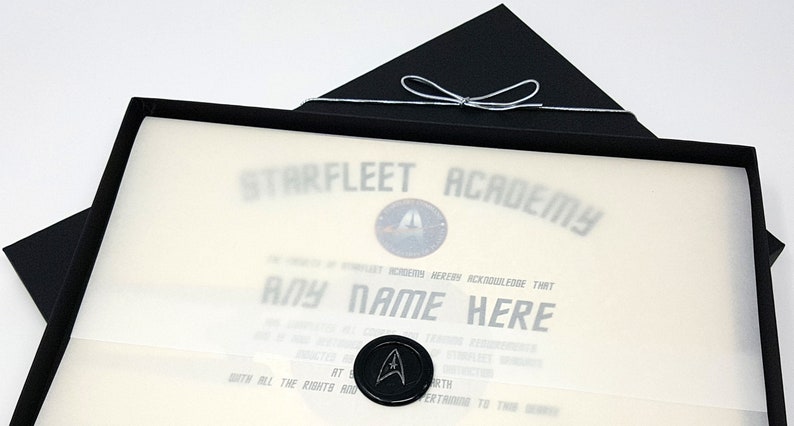 May include: A black box with a white certificate inside. The certificate is for Starfleet Academy and says "THEREBY ACKNOWLEDGE THAT ANY NAME HERE".