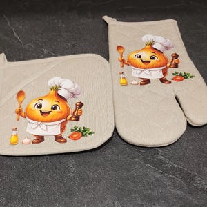 Peut inclure: Un ensemble manique et gant de cuisine matelassé beige orné d'un personnage oignon en dessin animé portant une toque et un tablier. Le personnage tient une cuillère en bois et un moulin à poivre, entouré d'huile d'olive, d'ail et de tomate.