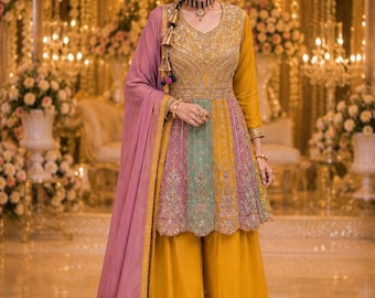 May include: A mustard yellow and lavender peplum-style tunic with intricate silver embroidery and a central mint green panel, paired with matching wide-leg trousers and a long, solid lavender dupatta with a gold-trimmed border and tassel accents.