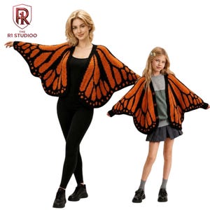 May include: Two matching open-front cardigans featuring a vibrant orange and black monarch butterfly wing pattern. The knit garments have wide, wing-like sleeves and black trim along the edges. The design mimics the distinct veining and color blocks of butterfly wings, creating a cohesive look for two different sizes.