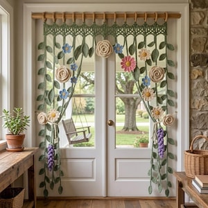May include: A crochet door curtain featuring green vines and leaves hanging from a wooden rod. The design includes various three-dimensional flowers in shades of cream, light blue, pink, and purple, arranged in a cascading floral pattern.