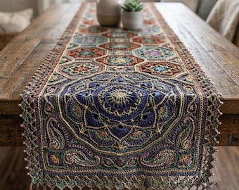 May include: A rectangular crochet table runner featuring a central dark blue mandala motif surrounded by repeating geometric patterns in shades of rust, teal, and gold. The edges are finished with a delicate scalloped border and small beads.