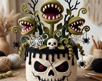 May include: A crocheted basket featuring a skull face with black eye sockets and a stitched mouth, topped with three green carnivorous plants with white teeth, black spider webs, small black spiders, and a small white skull.