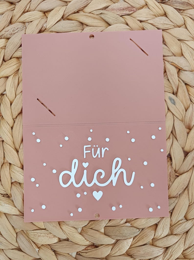 Peut inclure: Une carte rectangulaire rose poudr&eacute; avec le texte blanc F&uuml;r dich, signifiant Pour toi, centr&eacute; sur la moiti&eacute; inf&eacute;rieure. La carte est d&eacute;cor&eacute;e de petits points blancs et d'une ic&ocirc;ne de c&oelig;ur blanc dispers&eacute;s sur la partie inf&eacute;rieure.
