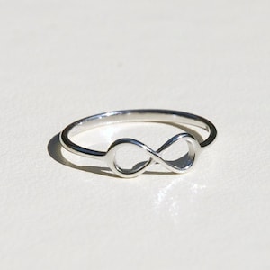 May include: A silver infinity ring with a simple design.