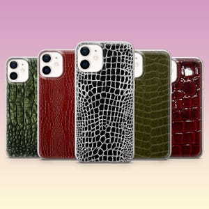 Peut inclure: Cinq coques de smartphone disposées en rangée, chacune présentant un motif texturé en peau de crocodile. Les couleurs incluent le vert foncé, le rouge profond, un noir et blanc contrasté, le vert olive et un fini rouge bordeaux brillant.