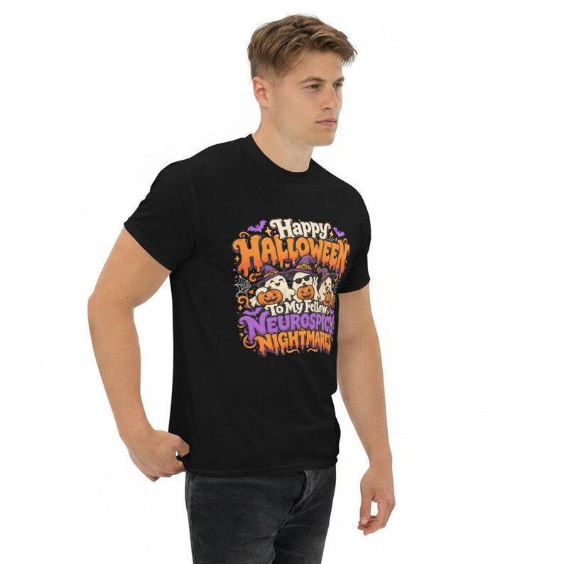 May include: A black short-sleeve t-shirt featuring a graphic print with the text Happy Halloween To My Fellow Neurospicy Nightmares. The design includes three white ghosts wearing purple witch hats and holding orange pumpkins with bats.