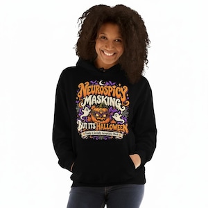 May include: A black hooded sweatshirt featuring a colorful graphic print with the text Neurospicy Masking But Its Halloween and Finally A Socially Acceptable Mask. The design includes a jack-o'-lantern wearing a purple mask, ghosts, and spiderwebs.