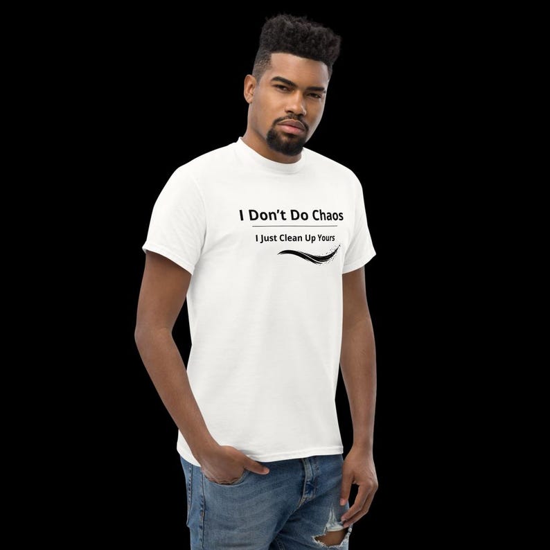 Op de afbeelding: Een wit T-shirt met korte mouwen voorzien van de zwarte tekst I Don't Do Chaos I Just Clean Up Yours met een decoratieve zwarte swoosh-afbeelding onder de tekst, op een effen witte stof.