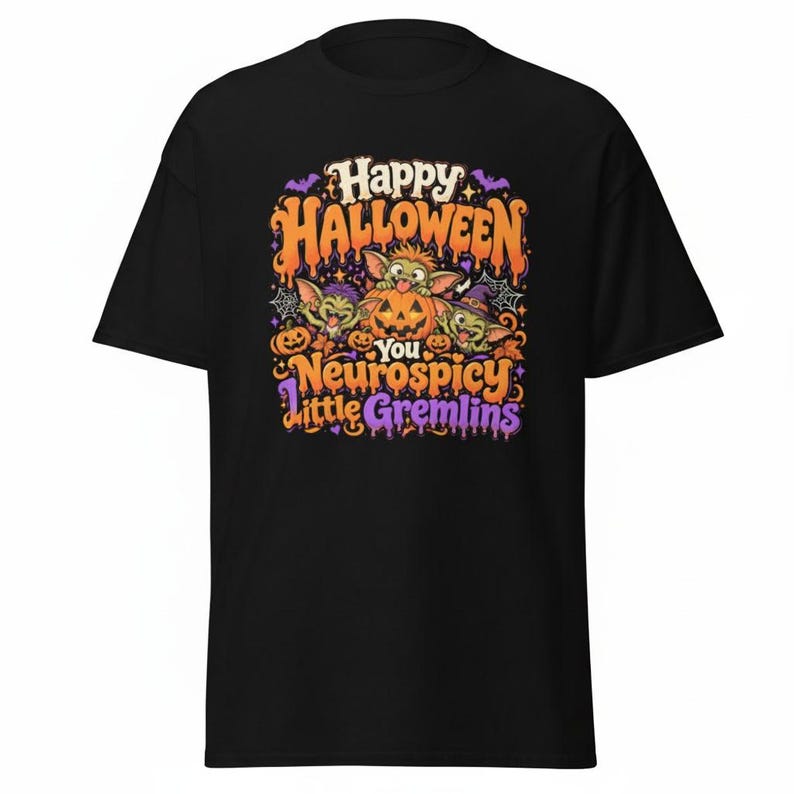 May include: A black t-shirt featuring a colorful graphic with three cartoon gremlins and pumpkins. The text reads Happy Halloween You Neurospicy Little Gremlins in orange and purple lettering, surrounded by spiderwebs, bats, and autumn leaves.