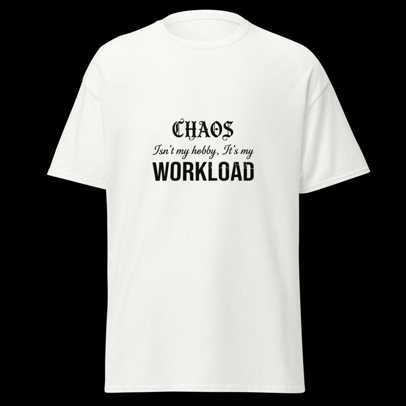 May include: A white short-sleeved t-shirt featuring black text printed on the chest. The text reads: CHAOS Isn't my hobby, It's my WORKLOAD. The shirt has a crew neckline and a standard fit, providing a clean and simple appearance for daily wear.