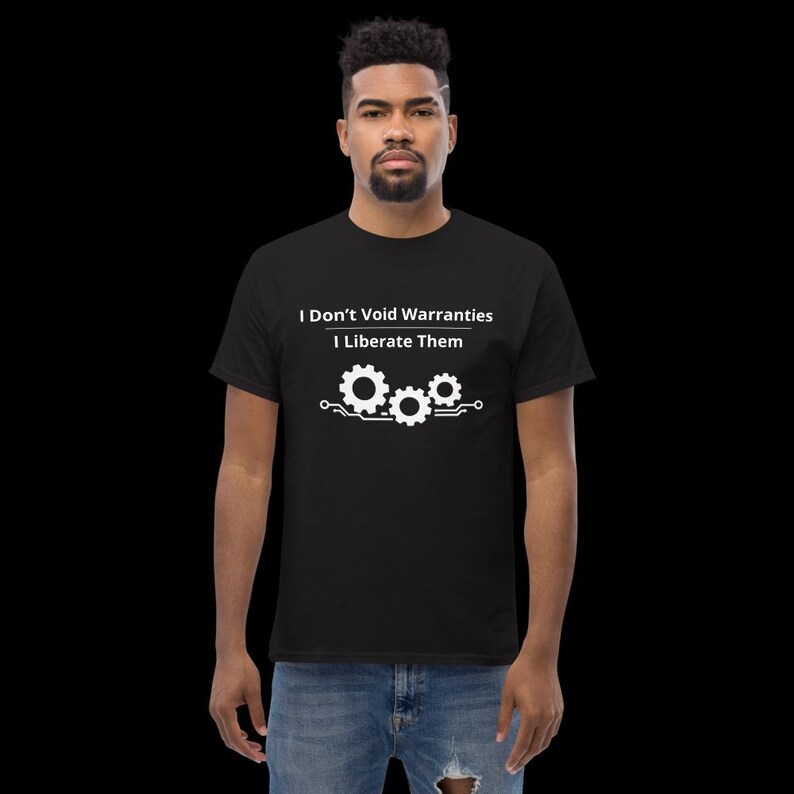 May include: A black short-sleeved t-shirt featuring white text that reads I Don't Void Warranties I Liberate Them above a graphic of three interconnected gears with circuit board lines extending from the sides, paired with blue denim jeans.
