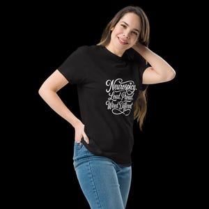 K&ouml;nnte beinhalten: Ein schwarzes Kurzarm-T-Shirt mit wei&szlig;em Schreibschrift-Text, der Neurospicy. Loud, Proud, Wired Different lautet, und einem Unendlichkeitssymbol unter dem Text. Das T-Shirt wird mit einer blauen Jeans kombiniert.