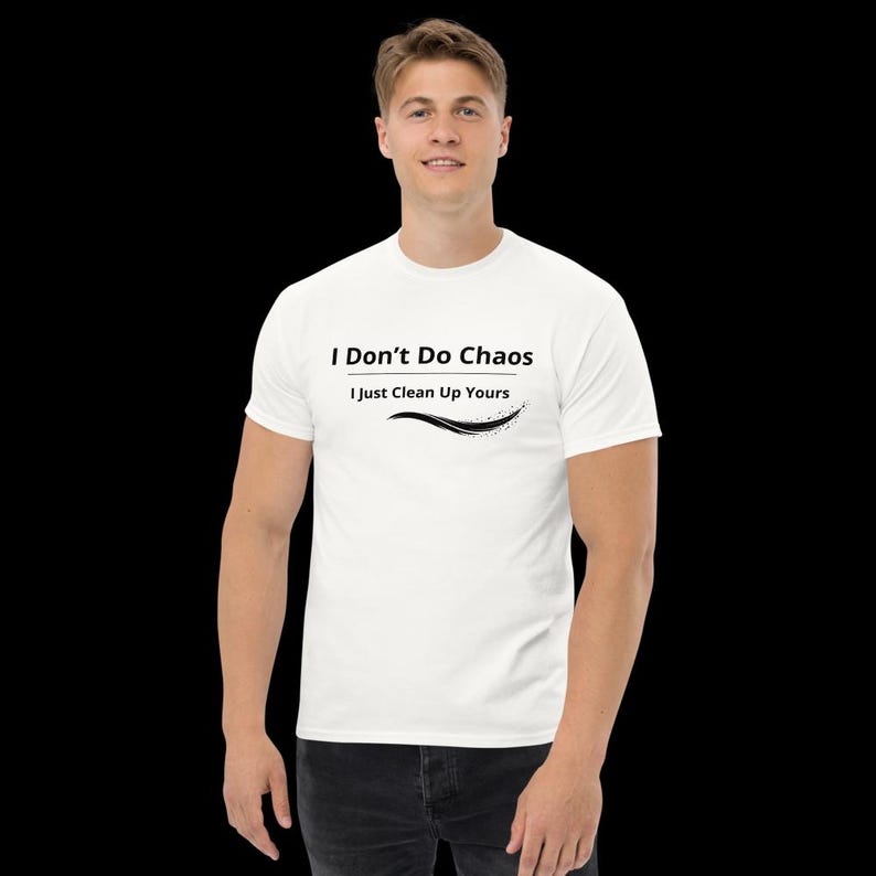 Op de afbeelding: Een wit T-shirt met korte mouwen en de zwarte tekst I Don't Do Chaos I Just Clean Up Yours, geplaatst boven een gestileerd zwart grafisch lijnelement. Het shirt heeft een ronde hals en een standaard pasvorm, gemaakt van katoenen stof.