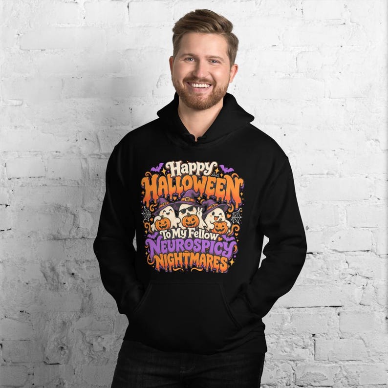 May include: A black hooded sweatshirt featuring a colorful graphic print with the text Happy Halloween To My Fellow Neurospicy Nightmares. The design includes three cartoon ghosts wearing purple witch hats and holding orange jack-o'-lanterns.
