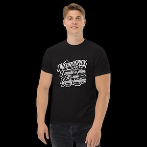 May include: A black short-sleeved t-shirt featuring white cursive text on the chest that reads: Neurospicy. I made a plan. It's now legally binding. The shirt has a crew neckline and a standard fit, providing a clean look for casual daily wear.