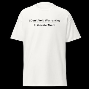 Puede incluir: Una camiseta blanca de manga corta con texto negro impreso en el pecho que dice, I Don't Void Warranties, con una línea horizontal debajo, seguido del texto, I Liberate Them, en un estilo de fuente sans-serif limpio.