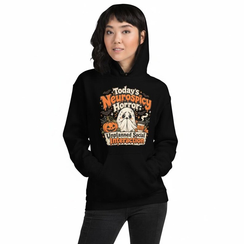 K&ouml;nnte beinhalten: Ein schwarzer Kapuzenpullover mit einem Grafikdruck und dem Text Today's Neurospicy Horror: Unplanned Social Interaction. Das Design zeigt ein Gespenst, einen K&uuml;rbis, einen Kaffeebecher, Flederm&auml;use und Spinnweben in Orange und Wei&szlig;.