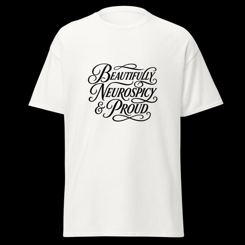 K&ouml;nnte beinhalten: Ein wei&szlig;es T-Shirt mit kurzen &Auml;rmeln und schwarzem, kursivem Text in der Mitte der Brust, der Beautifully Neurospicy & Proud lautet. Das Kleidungsst&uuml;ck hat einen klassischen Rundhalsausschnitt und eine Standardpassform mit klarem Design.