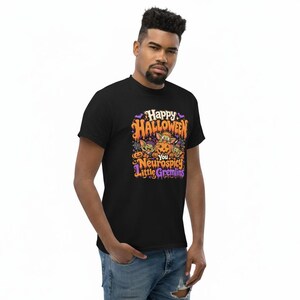 May include: A black short-sleeved t-shirt featuring a colorful graphic print with the text "Happy Halloween You Neurospicy Little Gremlins". The design includes illustrations of three small creatures, a carved pumpkin, bats, and spiderwebs.