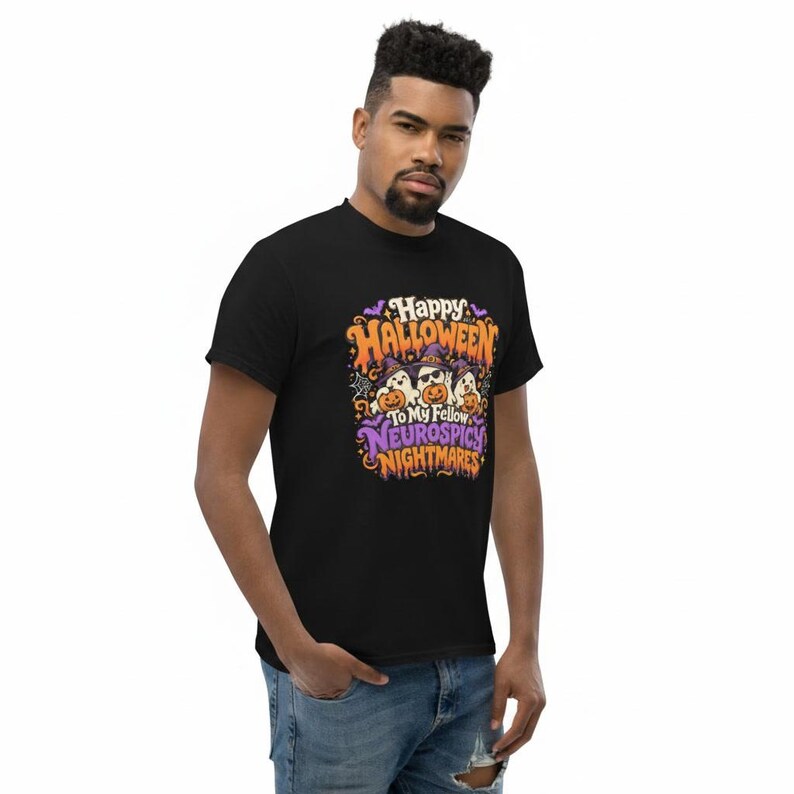 May include: A black t-shirt featuring a colourful graphic with three ghosts wearing witch hats and sunglasses, holding pumpkins. The text reads Happy Halloween To My Fellow Neurospicy Nightmares, surrounded by bats, stars, and spiderwebs.