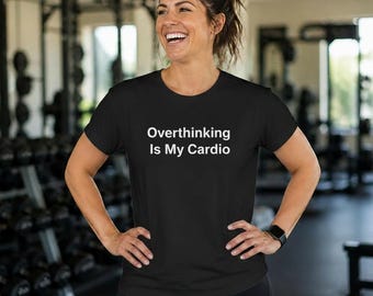 May include: A black short-sleeved t-shirt featuring the white text "Overthinking Is My Cardio" printed across the chest. The garment has a crew neckline and a standard fit, constructed from a solid black fabric with clean, white lettering.