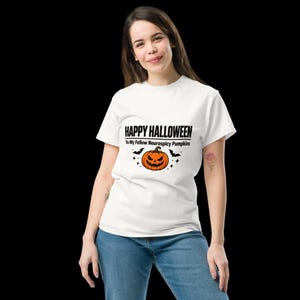 K&ouml;nnte beinhalten: Ein wei&szlig;es kurz&auml;rmeliges T-Shirt mit dem schwarzen Text HAPPY HALLOWEEN To My Fellow Neurospicy Pumpkins &uuml;ber einer orangefarbenen K&uuml;rbisgrafik, die von zwei kleinen schwarzen Flederm&auml;usen und Sternen auf der Brust flankiert wird.