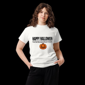 May include: A white short-sleeved t-shirt featuring the black text HAPPY HALLOWEEN and From One Neurospicy Disaster To Another, centered above an orange jack-o'-lantern graphic with a jagged, menacing facial expression and a brown stem.