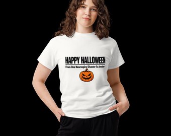 May include: A white short-sleeved t-shirt featuring the black text HAPPY HALLOWEEN and From One Neurospicy Disaster To Another, centred above an orange jack-o'-lantern graphic with a jagged, menacing facial expression and a brown stem.