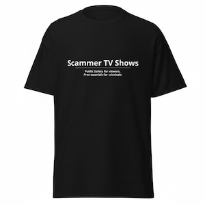 May include: A black short-sleeved t-shirt featuring white text on the chest that reads Scammer TV Shows, with the subtitle Public Safety for viewers. Free tutorials for criminals, separated by a horizontal line below the main title.