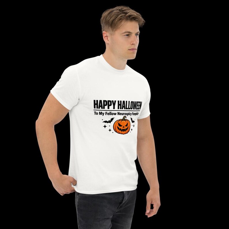 K&ouml;nnte beinhalten: Ein wei&szlig;es kurz&auml;rmeliges T-Shirt mit einem Aufdruck, der den Text HAPPY HALLOWEEN To My Fellow Neurospicy Pumpkin sowie einen orangefarbenen K&uuml;rbis, schwarze Flederm&auml;use und kleine Sterne im Brustbereich zeigt.